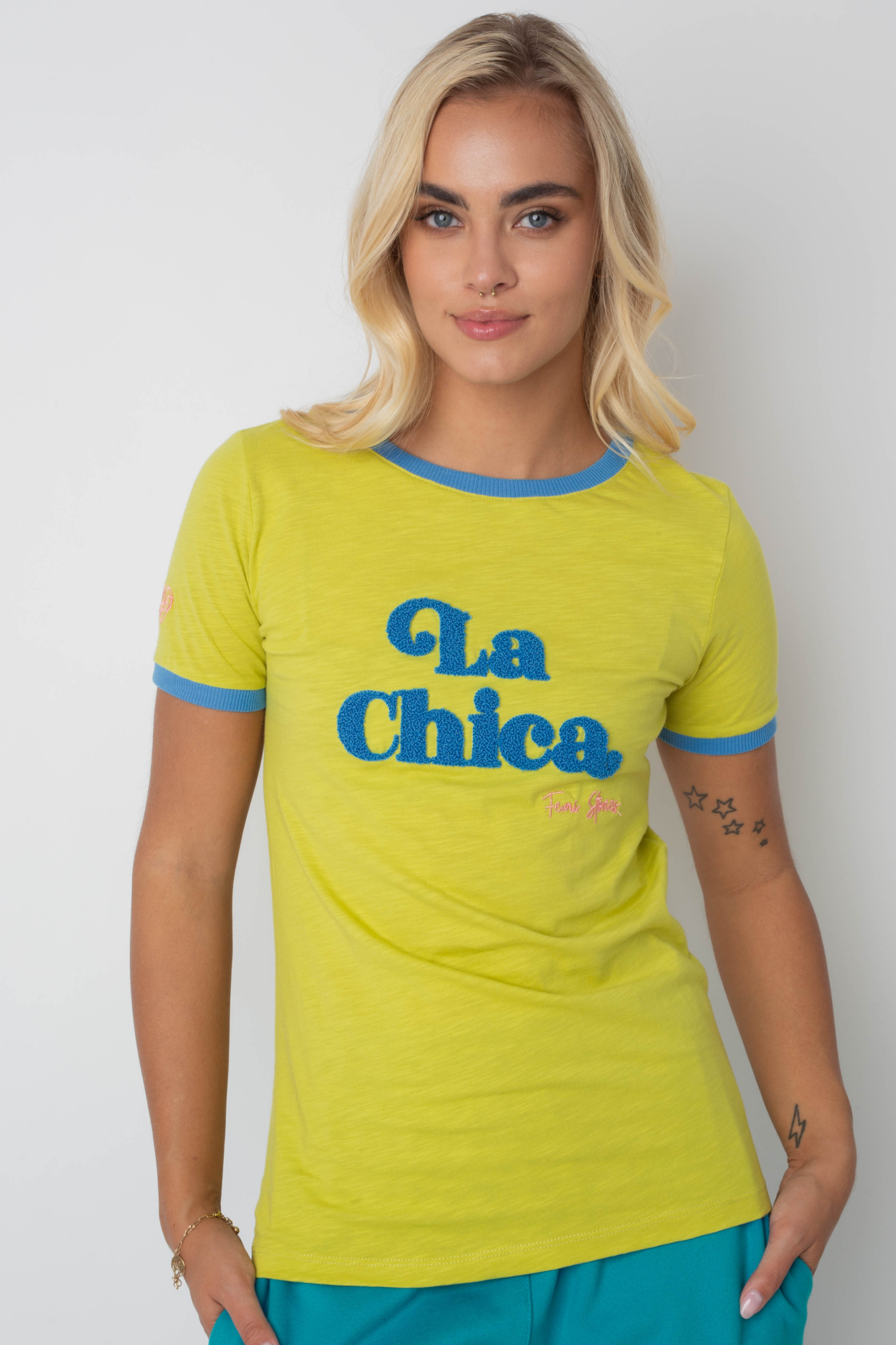 T-SHIRT LA CHICA JASNOZIELONA Z NIEBIESKIM NAPISEM I LAMÓWKĄ - COSMA