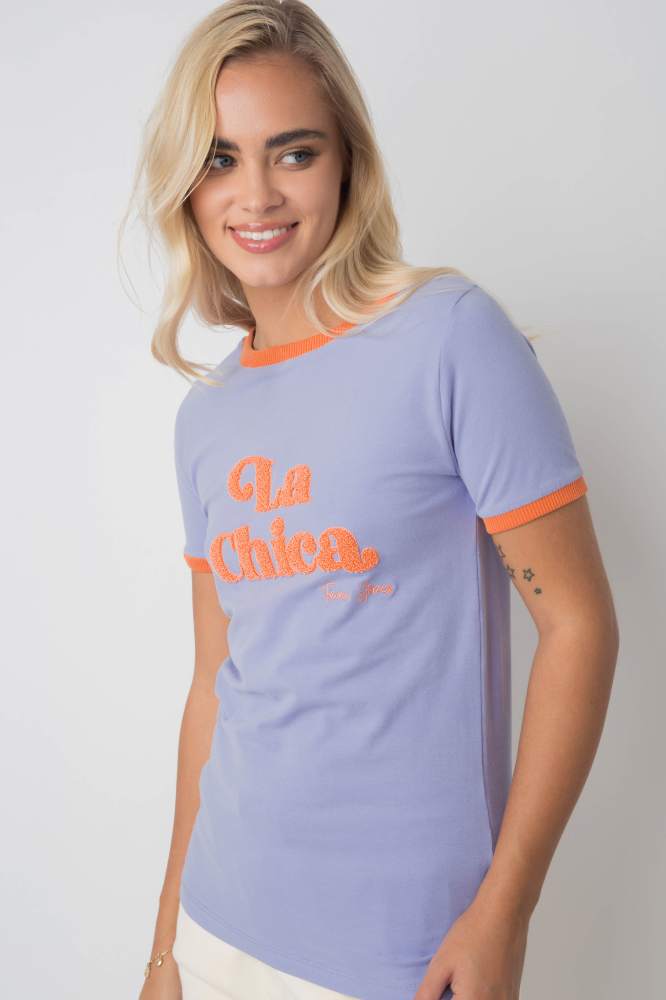 T-SHIRT LA CHICA LAWENDOWY Z POMARAŃCZOWYM NAPISEM I LAMÓWKĄ - COSMA